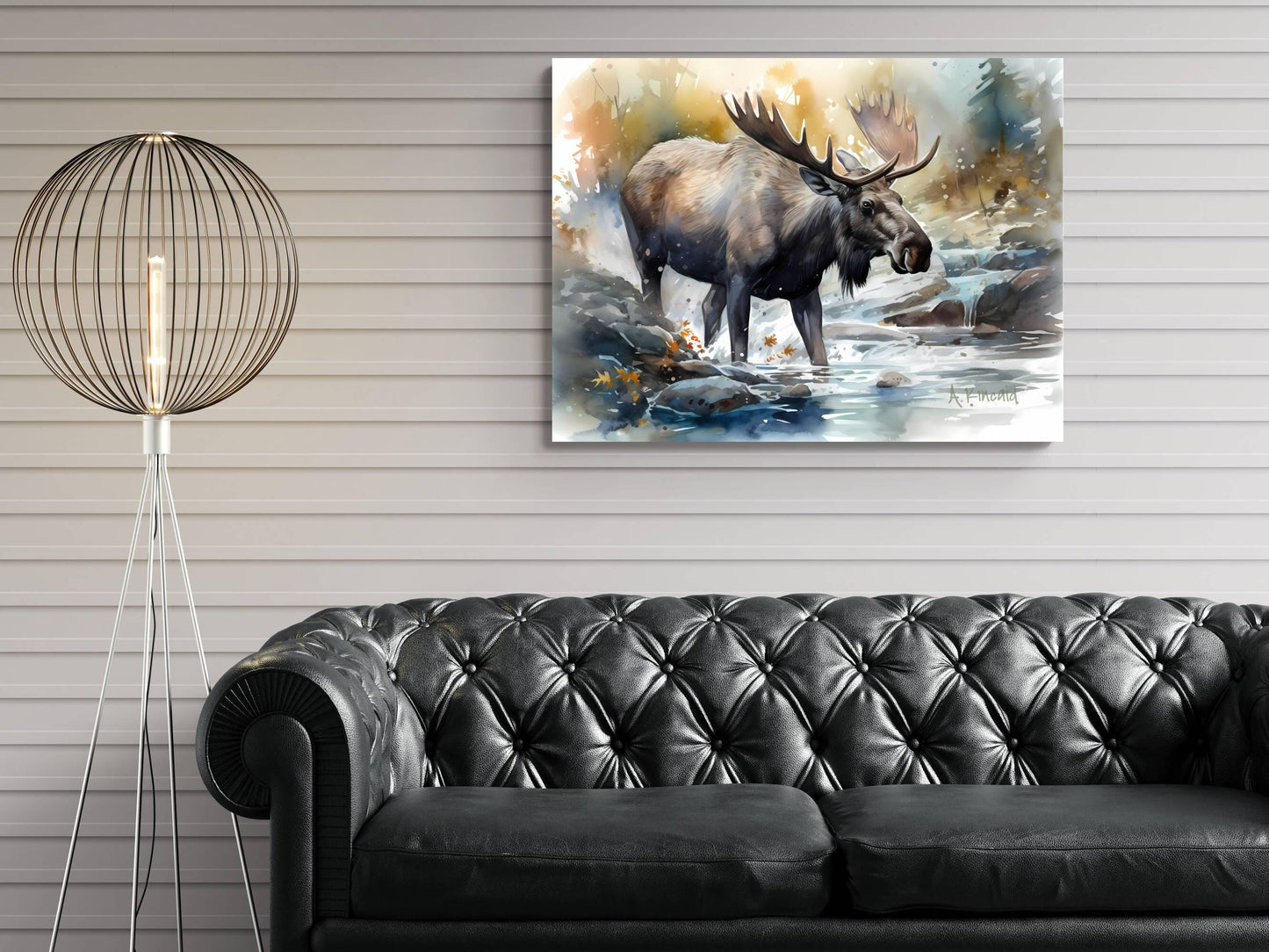 a large painting of a moose standing in a river, hanging on a wall above a black leather couch.