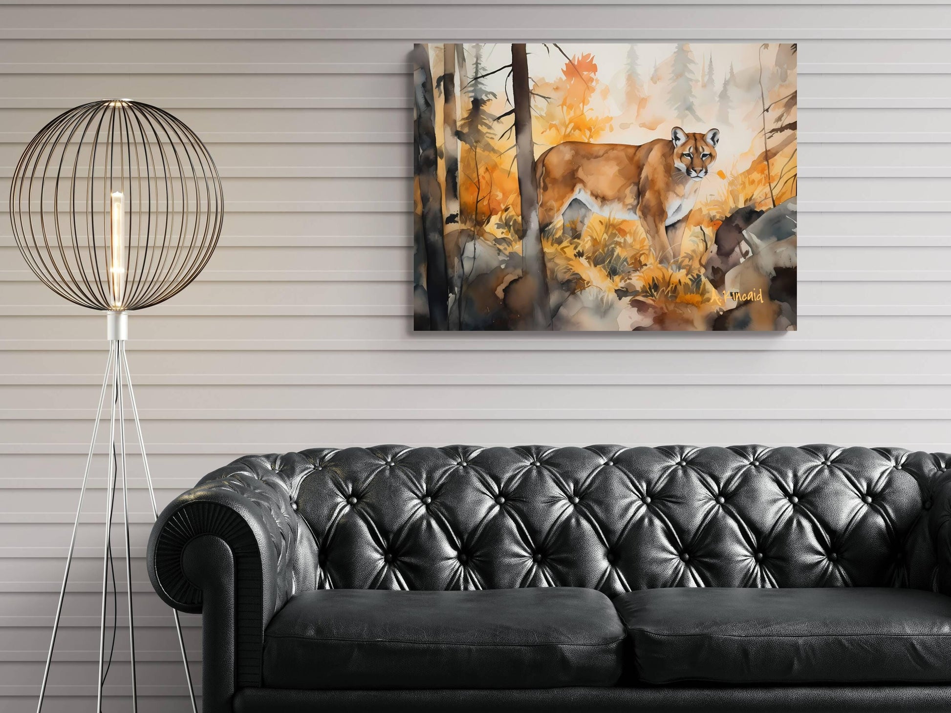 a black leather couch in a living room setting, with a painting of a cougar hanging on the wall above it.
