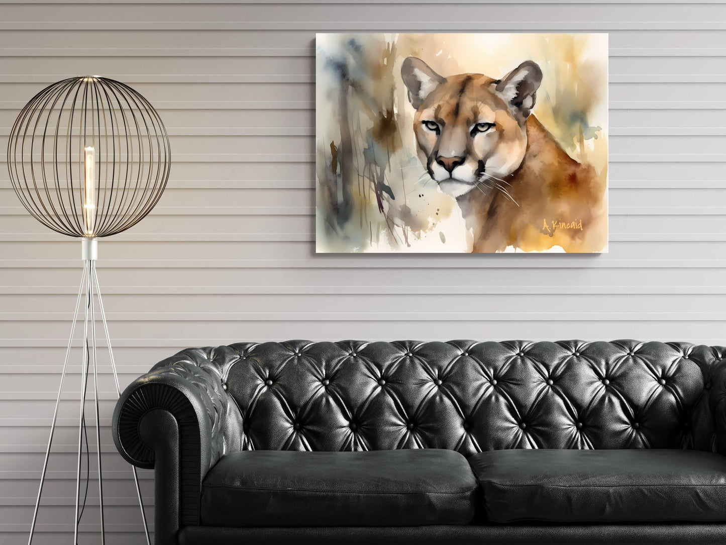 a black leather couch in a living room setting, with a painting of a cougar hanging on the wall above it.