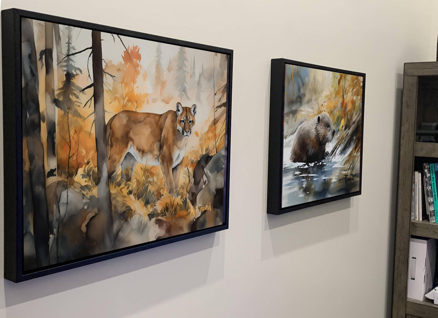 two framed paintings hanging on a wall, depicting wildlife in a forest setting.