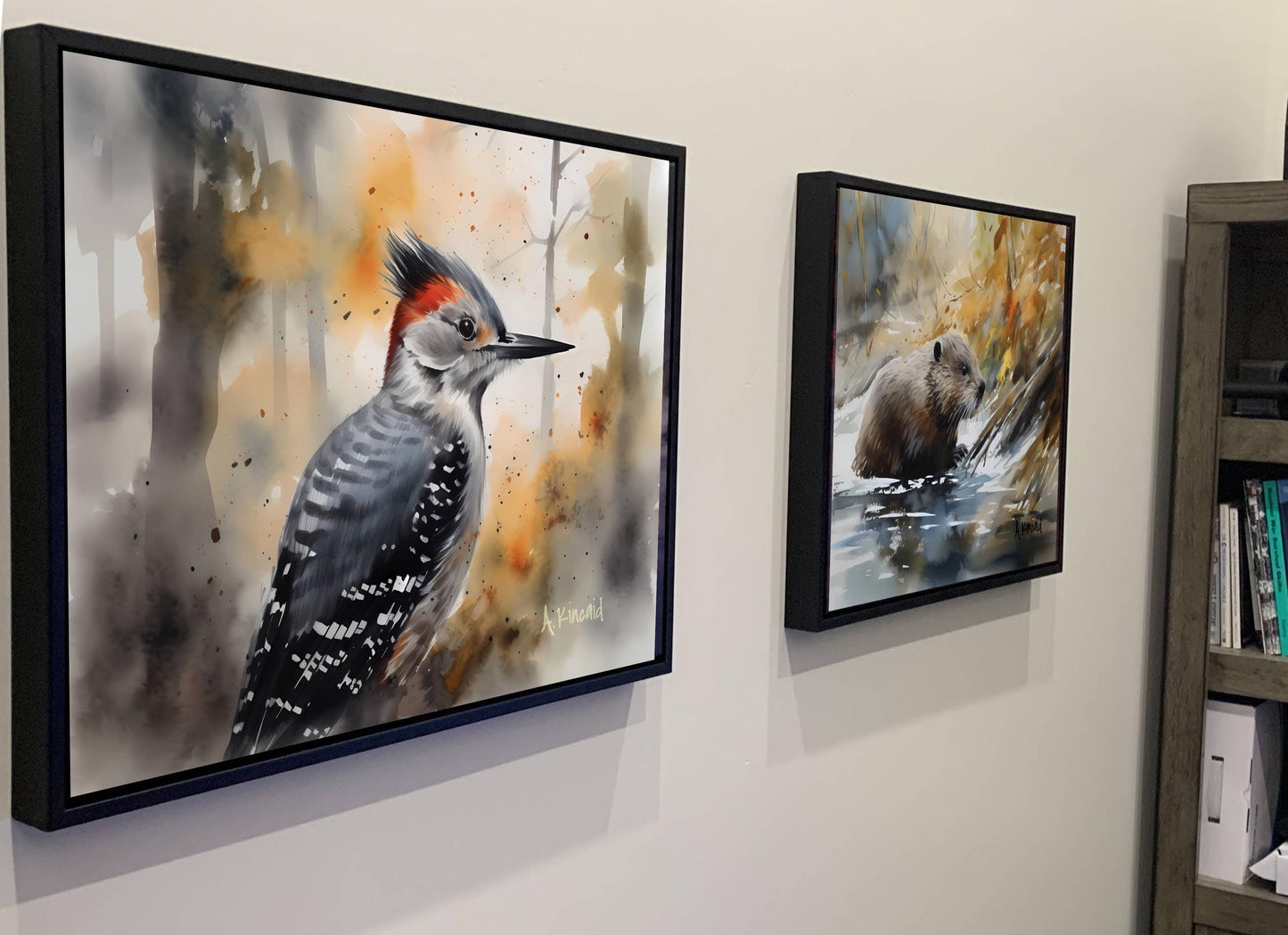 two framed paintings hanging on a wall, depicting a woodpecker and a beaver in their natural habitats.