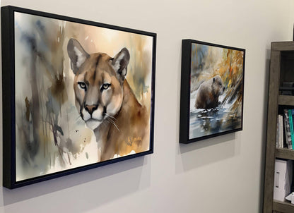 two framed paintings hanging on a wall, depicting a cougar and a bear in their natural habitats.
